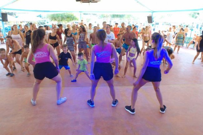 Un gruppo di persone partecipa a una lezione di danza in un'area coperta.