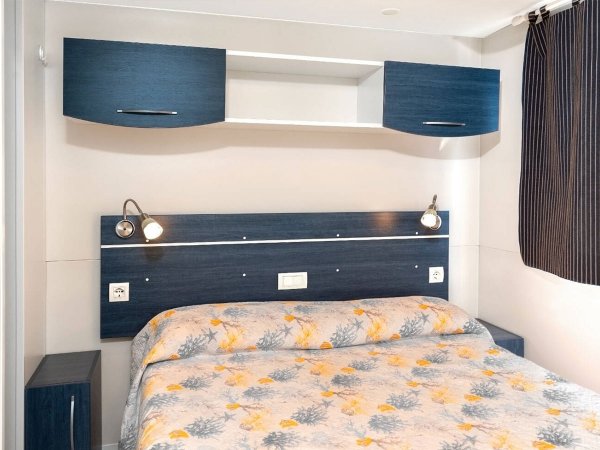 Camera da letto con letto matrimoniale e mobili blu.