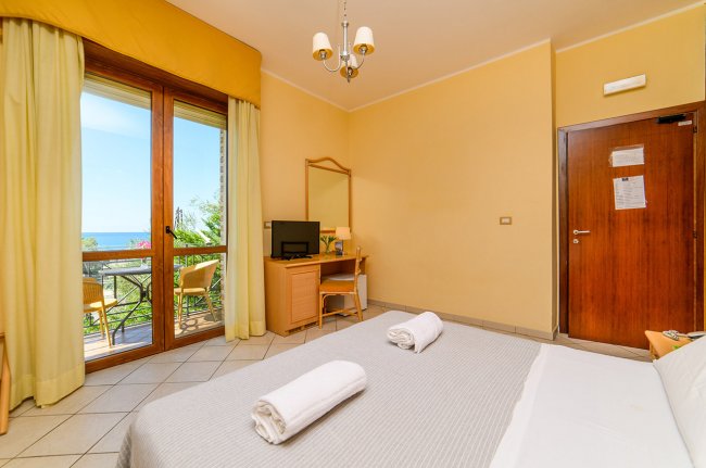 Camera da letto con balcone e televisore.