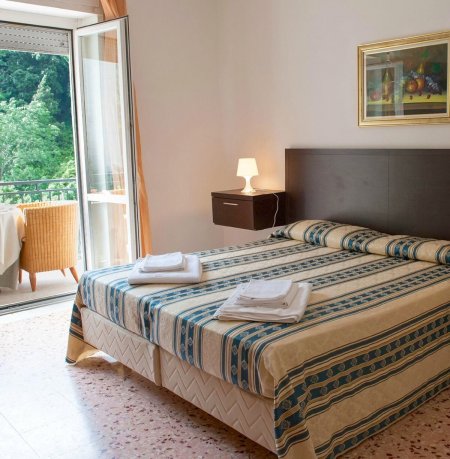 Camera da letto con letto matrimoniale e balcone.