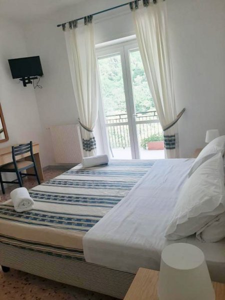 Camera con letto matrimoniale, TV e vista balcone.