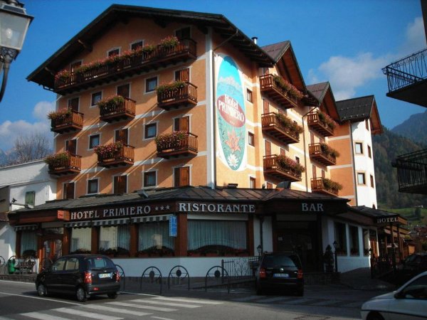 Facciata di un hotel con balconi fioriti.