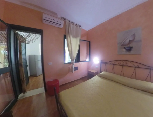 Camera con letto matrimoniale, armadio e decorazioni a parete.