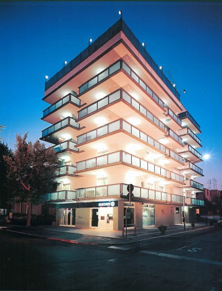 Edificio moderno con balconi illuminati di notte.