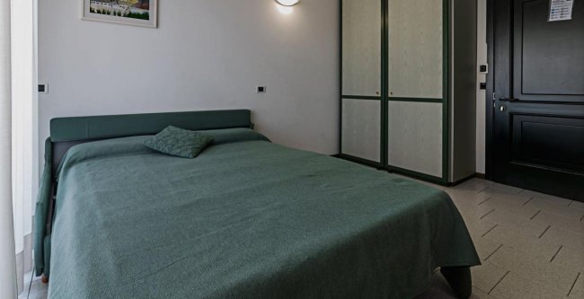Camera da letto semplice con letto matrimoniale e armadio.