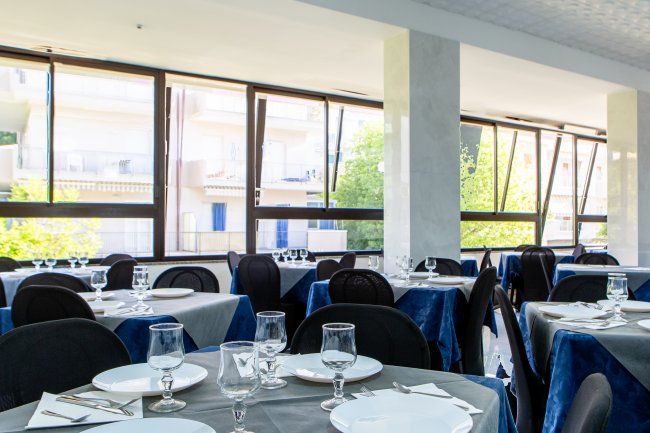 Ristorante luminoso con tavoli apparecchiati.