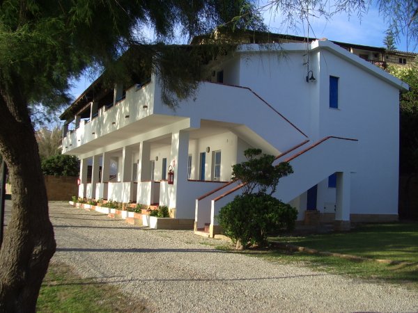 Edificio a due piani bianco con balconi.