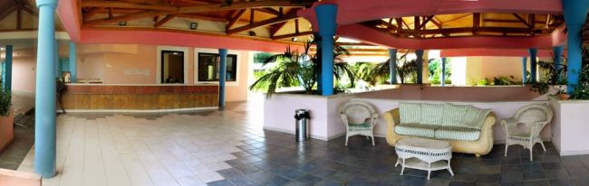 Salotto con divani bianchi e colonne colorate in un'area aperta.