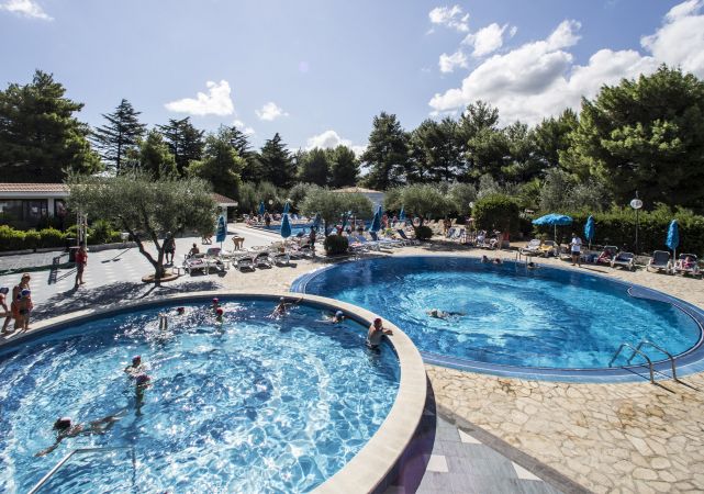 Due piscine all'aperto con persone che nuotano.