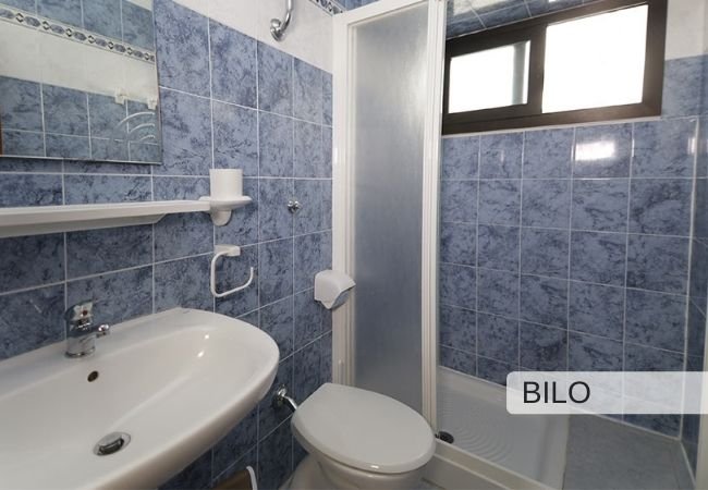 Bagno con piastrelle blu e doccia.