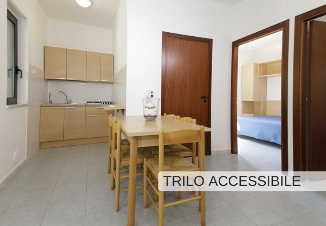 Cucina e sala da pranzo accessibile con tavolo in legno.