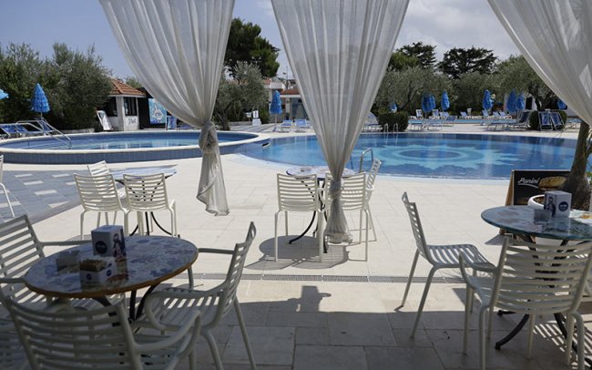 Tavoli e sedie vicino a una piscina.