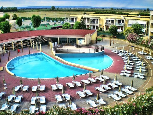 Ampia piscina circondata da lettini e ombrelloni.