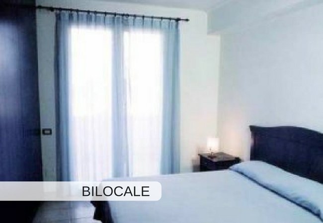Camera da letto con letto matrimoniale e finestra.