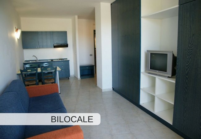 Soggiorno con cucina, divano e TV.