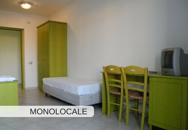 Letto singolo con armadio e tavolo.