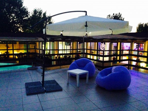 Sedie a sacco viola e ombrellone su terrazza.