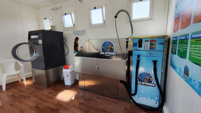 Stanza con lavatrice, vasca e attrezzature per il lavaggio.