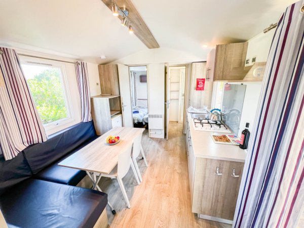 Cucina e soggiorno luminosi con tavolo da pranzo.