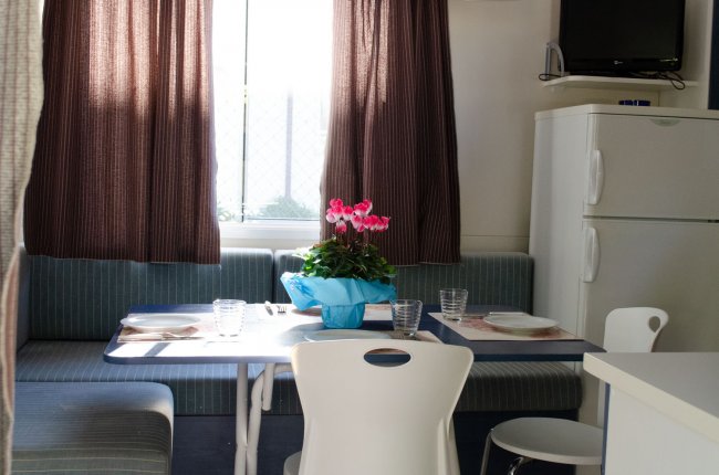 Tavolo da pranzo con fiori e sedie bianche.