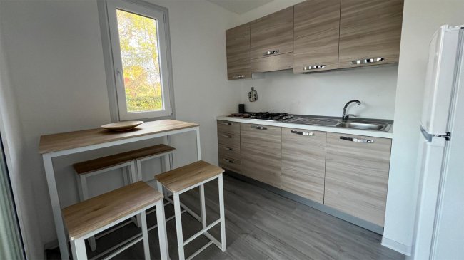 Cucina moderna con tavolo alto e sgabelli.