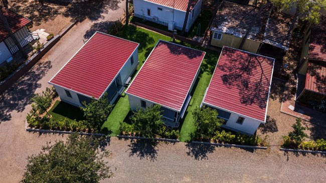 Vista aerea di tre case con tetti rossi.