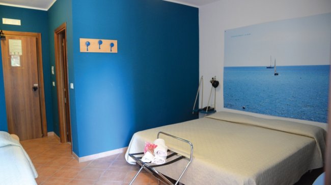 Camera con letto matrimoniale e decorazione marina.