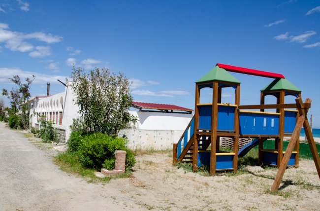 Parco giochi colorato vicino a un edificio bianco.
