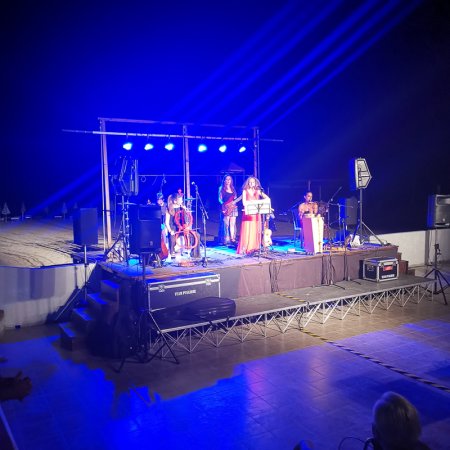 Musicisti su un palco illuminato di blu.