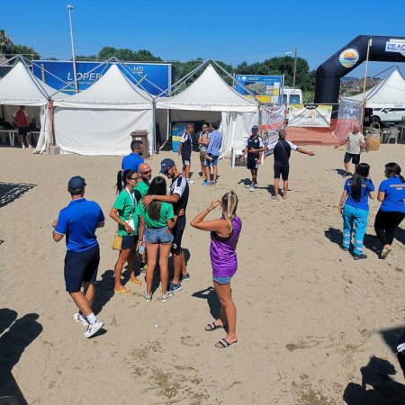 Gruppo di persone che conversano su una spiaggia.