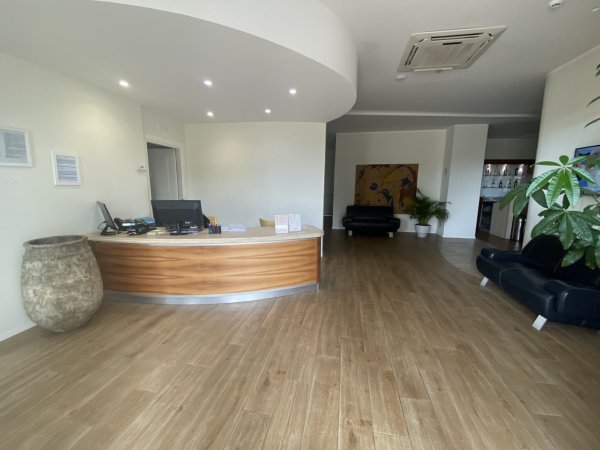 Area reception con scrivania in legno e divani.