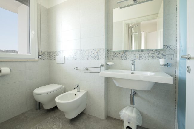 Bagno moderno con bidet e finestra.