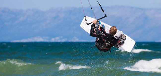 Un kitesurfer in aria sul mare mosso.