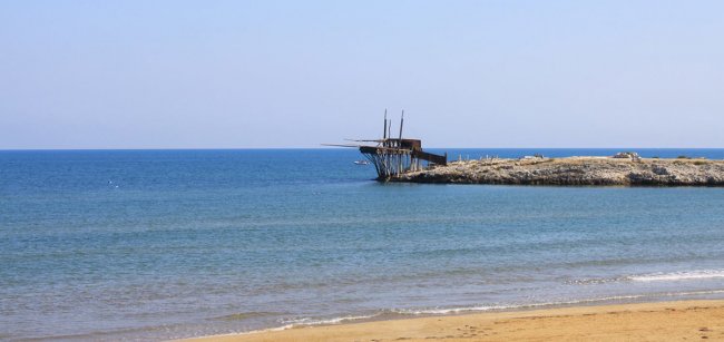 Una struttura in legno su una scogliera vicino al mare.