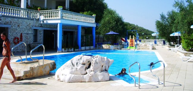 Piscina con scivolo colorato e ampia terrazza.