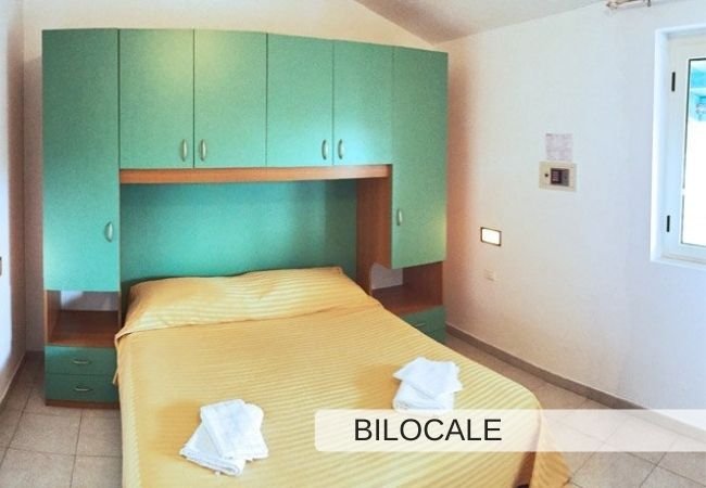 Camera con letto matrimoniale e mobili verdi.