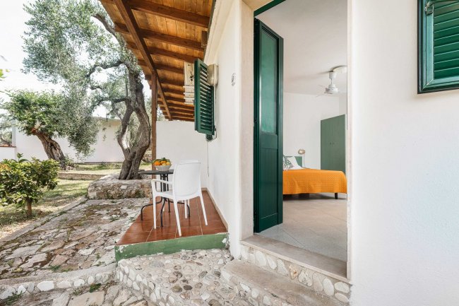 Ingresso camera con letto arancione, vista giardino.